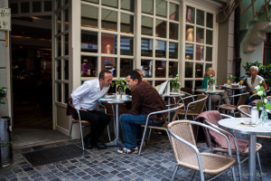 Two men seated at outdoor coffeeshop tables, Regensburg Germany