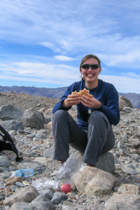 Woman sitting over Laguna de Los Tres with her lunch, Patagonia Argentina