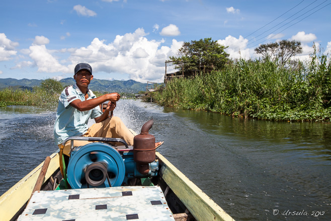 Burmese man on the controls of a longtail boat, Inle Lake, Myanmar