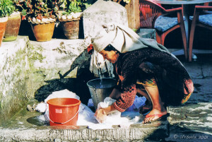 Nepalese woman doing laundry at the town tap, Tirkedunga, the Annapurnas, Nepal