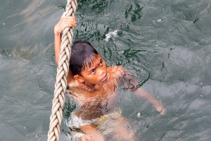 Portrait of a Batak youth hanging from a ferry line, Lake Toba, Samosir Island, North Sumatra