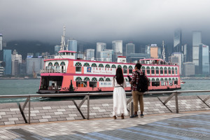Young Couple watching a large pink paddle boat, Victoria Harbour, Hong Kong