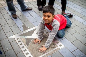Young boy putting his hands on the Handprints, Avenue of Stars in Tsim Sha Tsui, Hong Kong