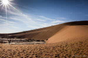 Sun rising behind tourists, Deadvlei, Namib-Naukluft Park, Namibia