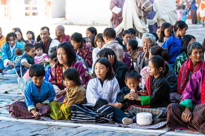 Bhutanese villagers seated on mats, Wangduephodrang Dzongkhag Dzong, Central Bhutan.