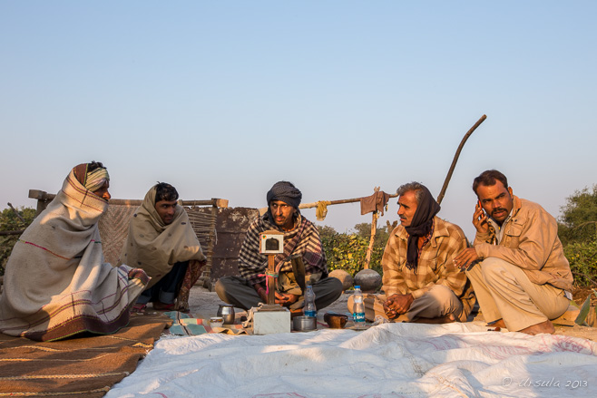 Bishnoi men seated around an opium filtration system, Rajasthan India
