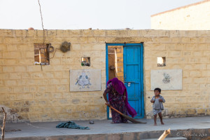 Rajasthani woman sweeping a cement porch, Khuri Village