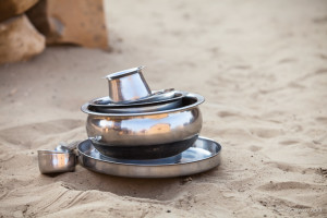 Aluminum pots and plates on the sand, Khuri Village