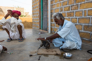 Rajasthani man fixing machinery, Khuri Village