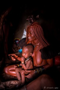Himba Mother and Child in a dark hut, Otjomazeva Village Namibia