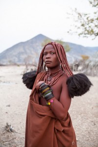 Himba woman wrapped in a cow hide, Otjomazeva Village Namibia