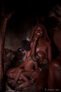 Himba Mother and Child in a dark hut, Otjomazeva Village Namibia