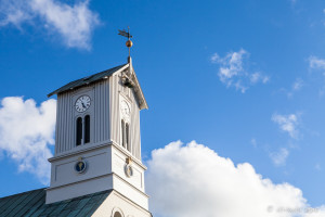 Clock tower of the Reykjavík Cathedral against a blue sky.