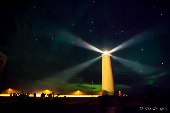 Garðskagi Lighthouse under a black, starry sky with a trace of green aurora, Iceland