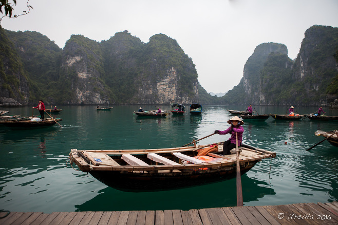 Female rower sitting in a wooden boat, Vung Vieng, Bai Tu Long Bay, Vietnam