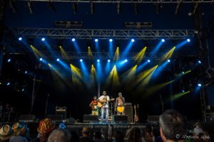 Indigenous band members from East Journey under blue and yellow Lights, Byron Bay Bluesfest 2016