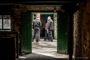 Brewery workers outside old, dark buildings, Kilbeggan Distillery, County Westmeath, Ireland