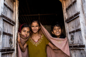 Three young Rajasthani Faces in an open Doorway Thar Desert village, India