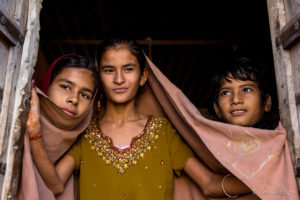 Three young Rajasthani Faces in an open Doorway Thar Desert village, India
