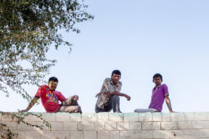 Three Indian men on a brick Wall, Rajasthan