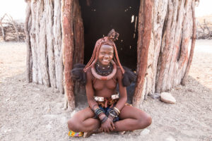 Young Himba woman outside a sleeping hut, Otjomazeva Village, Kunene Namibia