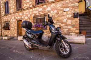 Black scooter in a Castiglione del Lago Street, Italy