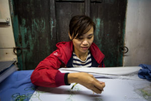 Vietnamese woman doing embroidery in the Phung Hung Old House, Hoi An Vietnam
