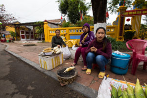 Three women with cooked corn on a Hoi An street, Vietnam