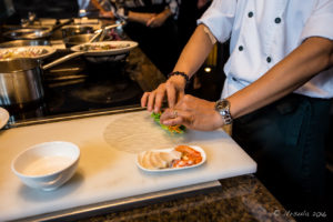 Man in white uniform Rolling Spring Rolls, Hay Hay Restaurant Display Kitchen, Naman Retreat Danang Vietnam
