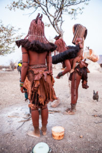 Back view of two Himba women in their leather skirts, Kunene Region Namibia