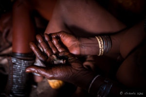 Himba woman hands mixing Otjize, Kunene Region Namibia
