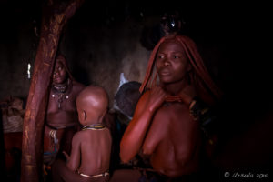 Himba woman oiling herself with ochre powder, Kunene Region Namibia