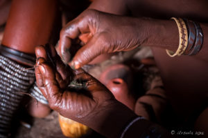 Himba woman hands mixing Otjize, Kunene Region Namibia