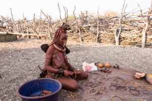 Himba woman laying Trinkets out on a blanket, Kunene Region Namibia