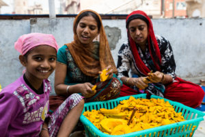 Young Indian women at cutting pumpkin on the roof, Gurudwara Sis Ganj Sahib, Chandni Chowk, Old Delhi