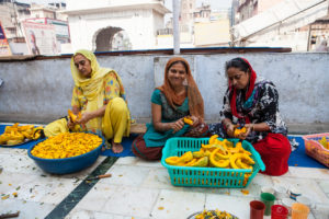 India Women at cutting pumpkin on the roof, Gurudwara Sis Ganj Sahib, Chandni Chowk, Old Delhi