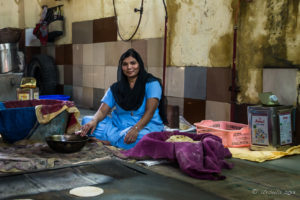 Sikh woman cooking chapati on a large griddle, Gurudwara Sis Ganj Sahib, Chandni Chowk, Old Delhi