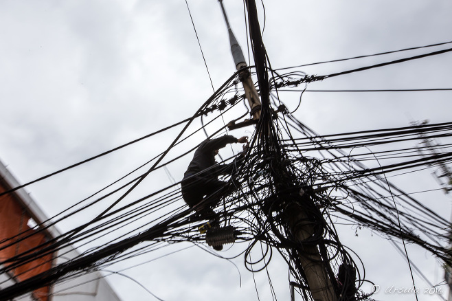 Silhouette of a man against phone and electrical wires, Danang Vietnam