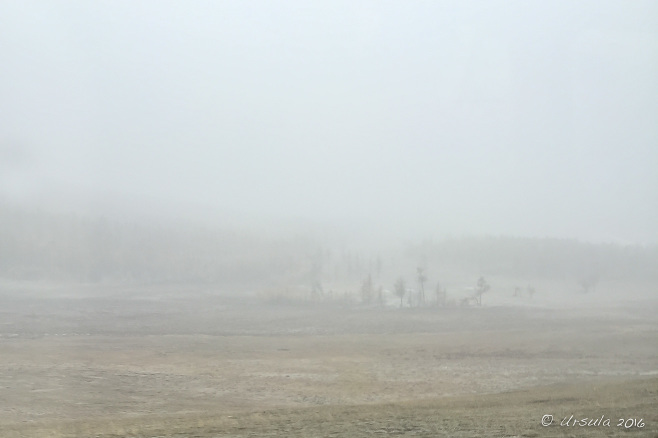 View through fog and snow over open barren Mongolian steppes.