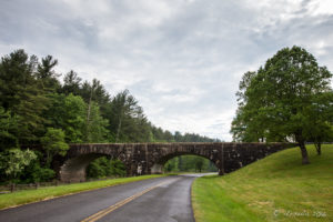 View through a windscreen of a stone road bridge, Blue Ridge Parkway, NC USA