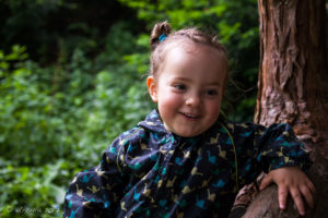 Portrait of a young girl in a tree, The Weir riverside garden, Herefordshire, UK