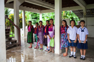 Thai school girls in school uniforms and traditional Lisu dresses, Chumchon Lae Luang Prasit Wittaya Primary School speaking to young pupils, Chiang Mai Thailand