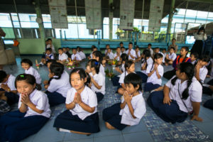 Thai school children sitting on a school auditorium floor, Chiang Mai Thailand