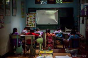 Children in a dark Ban Huay Mae Gok School classroom, Mae Sariang, Thailand