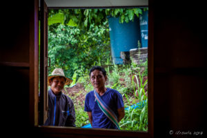 Two Thai men outside a shuttered window, , outside a shuttered WIndow, Mae Sariang, Thailand