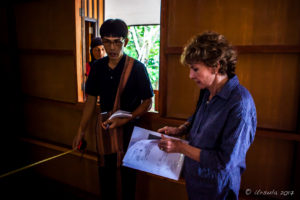 Woman with plans in a dark wooden building, Mae Sariang, Thailand