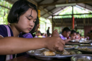 Karen schoolgirl eating Lunch, Mae Sariang Thailand