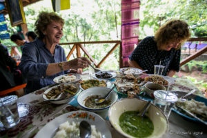 Women laughing over a northern Thai meal, Mae Sariang Thailand