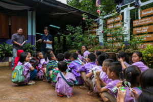 Karen children squatting in a school courtyard, Mae Sariang, Thailand