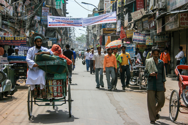 Pedestrians and cycle-rickshaws in a Chandni Chowk Street, Old Delhi, India.